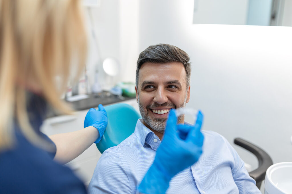 A young female dentist showing invisalign to patient in dental clinic, teeth check-up and Healthy teeth concept